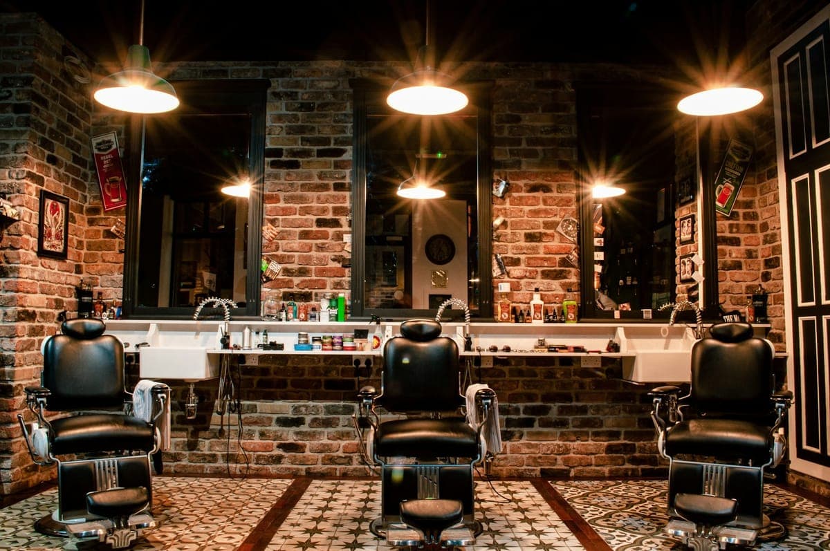 Intérieur d’un barber shop, fauteuils en cuir et murs de briques
