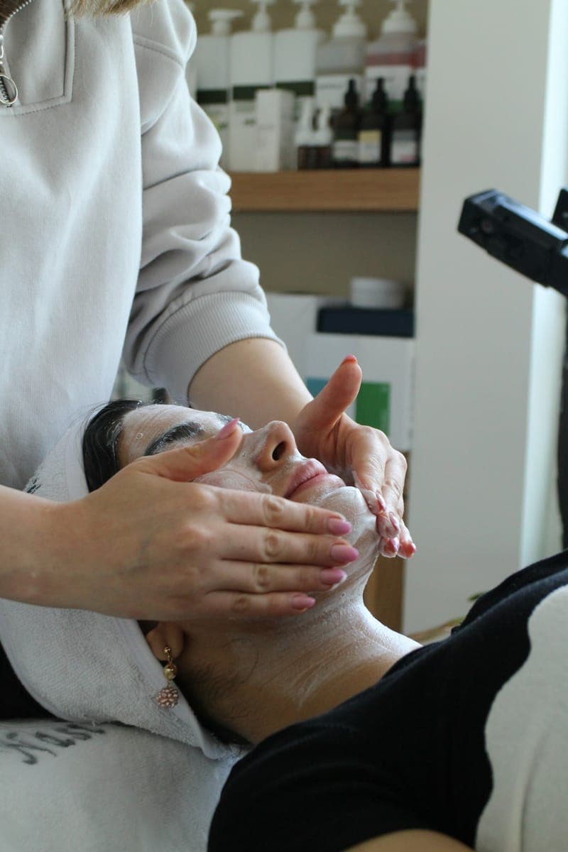 Une esthéticienne réalise un soin du visage dans un institut de beauté.